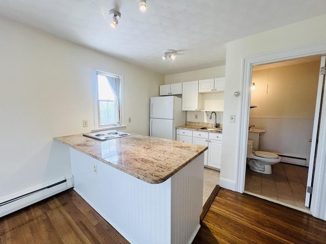 189 Concord Ave Unit 3, Cambridge, MA 02138 - kitchen featuring white appliances, baseboard heating, wood finished floors, and a peninsula