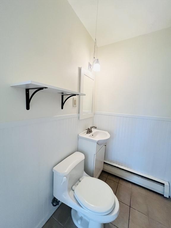 189 Concord Ave Unit 3, Cambridge, MA 02138 - half bathroom featuring a wainscoted wall, a baseboard radiator, tile patterned flooring, and vanity