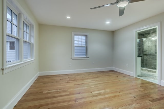 spare room featuring ceiling fan, a wealth of natural light, and light hardwood / wood-style flooring