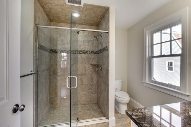 bathroom with toilet, a shower with door, and vanity