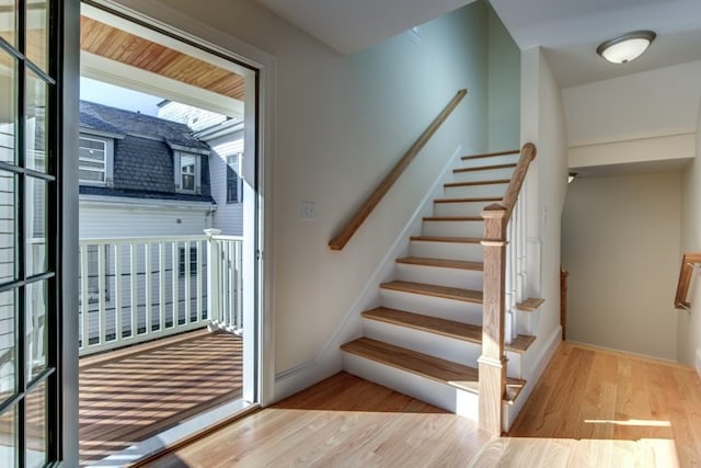 stairs with wood-type flooring and a healthy amount of sunlight