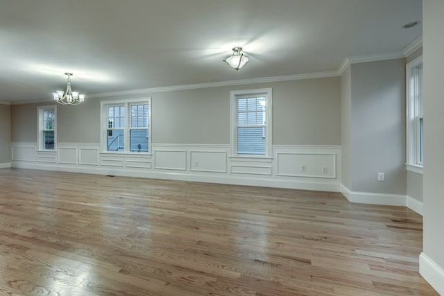 unfurnished living room featuring plenty of natural light, ornamental molding, and light wood-type flooring