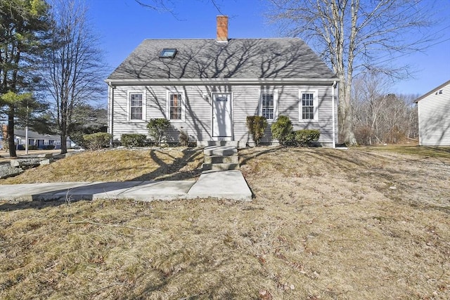 cape cod home featuring a shingled roof, entry steps, and a chimney