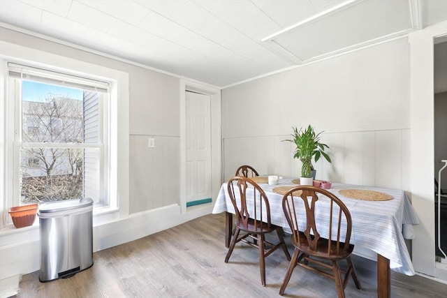 dining area with a wainscoted wall and wood finished floors