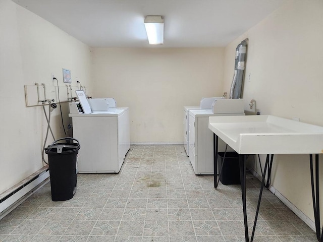 clothes washing area featuring washer and dryer and a baseboard heating unit