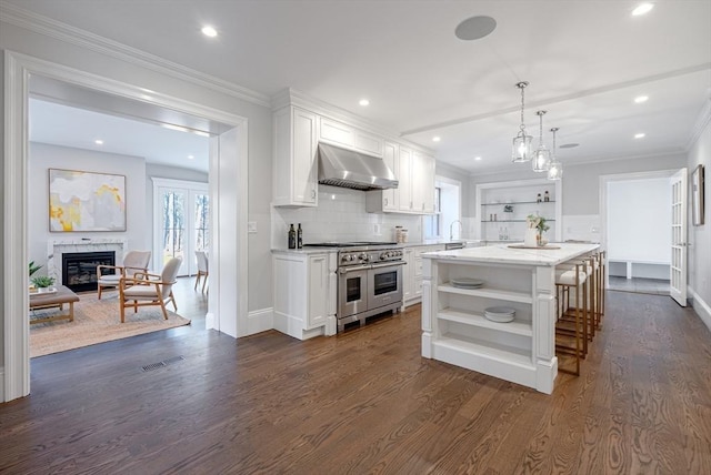 kitchen with a kitchen island, extractor fan, range with two ovens, and white cabinets