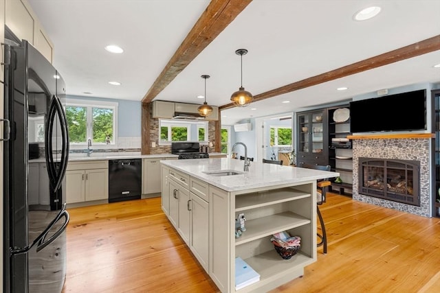 94 Kimball Rd, Amesbury, MA 01931 - kitchen featuring black appliances, healthy amount of natural light, light wood-type flooring, beamed ceiling, and a tiled fireplace