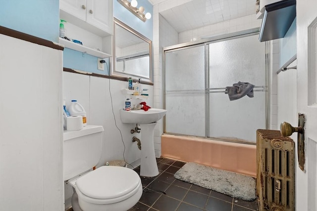 69 Conwell Ave, Somerville, MA 02144 - full bath with radiator heating unit, toilet, tile patterned flooring, and bath / shower combo with glass door