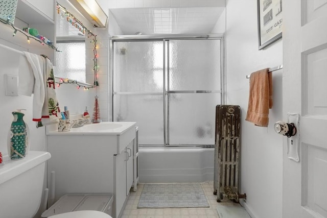 69 Conwell Ave, Somerville, MA 02144 - bathroom featuring radiator, vanity, toilet, and bath / shower combo with glass door