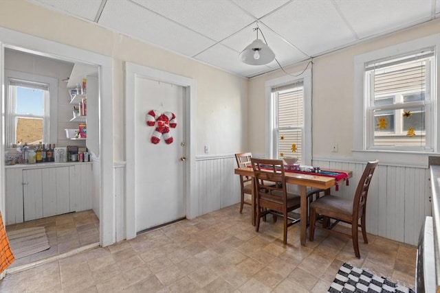 69 Conwell Ave, Somerville, MA 02144 - dining area featuring wainscoting, stone finish flooring, and wooden walls
