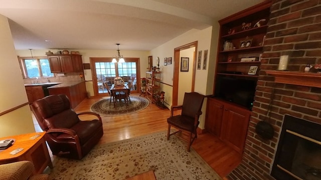 living room with an inviting chandelier, light hardwood / wood-style flooring, and plenty of natural light