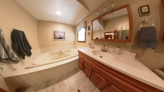 bathroom featuring tiled tub, vanity, and tile patterned floors