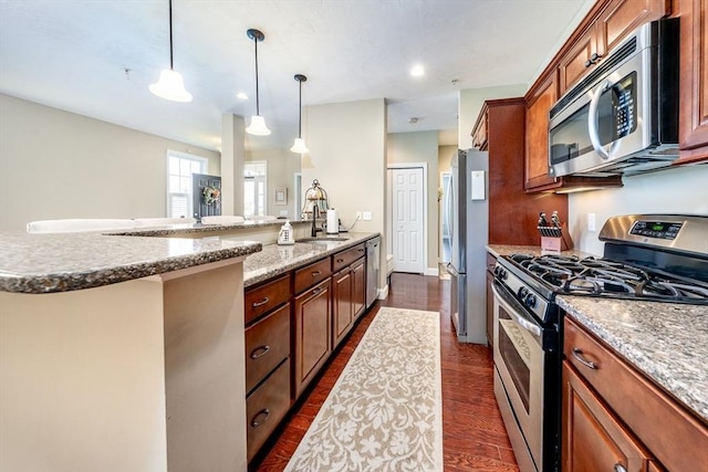 16 Twin Oaks Dr Unit 732, Mashpee, MA 02649 - kitchen with brown cabinetry, dark wood-style flooring, appliances with stainless steel finishes, hanging light fixtures, and a sink