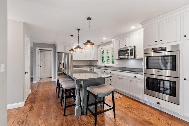 3 Chad Ln, Sterling, MA 01564 - kitchen with stainless steel appliances, a sink, white cabinets, a breakfast bar area, and recessed lighting