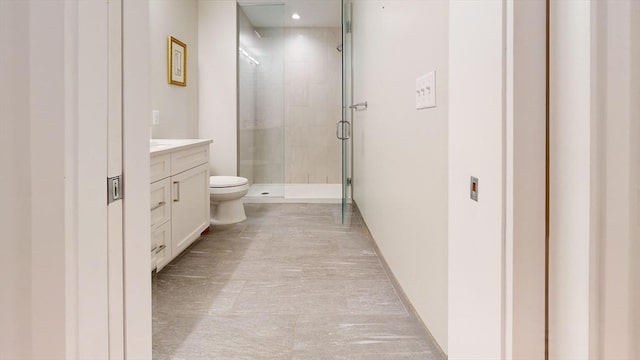 bathroom with walk in shower, vanity, and toilet