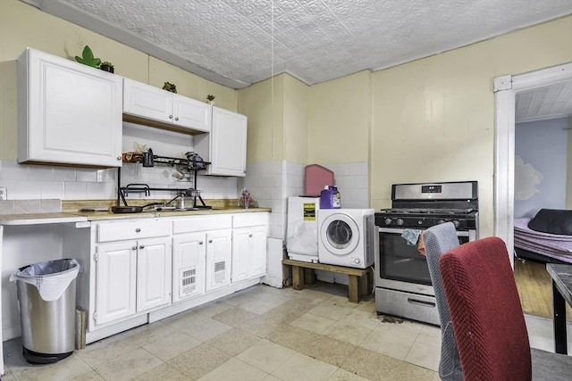 77-79 Grenada Ter, Springfield, MA 01108 - kitchen with gas stove, washer / clothes dryer, light countertops, and white cabinets