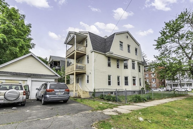 77-79 Grenada Ter, Springfield, MA 01108 - view of side of home featuring a gambrel roof, a balcony, a shingled roof, and a detached garage