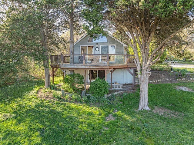 back of house featuring a wooden deck and a lawn
