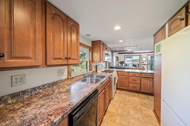 kitchen featuring white appliances, a sink, brown cabinetry, recessed lighting, and track lighting