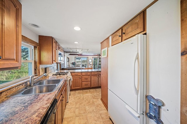 kitchen with white appliances, a sink, brown cabinets, recessed lighting, and a peninsula