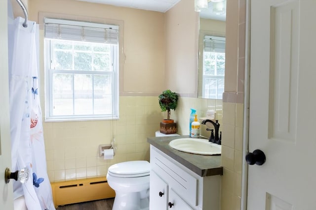bathroom featuring a baseboard heating unit, tile walls, vanity, toilet, and curtained shower