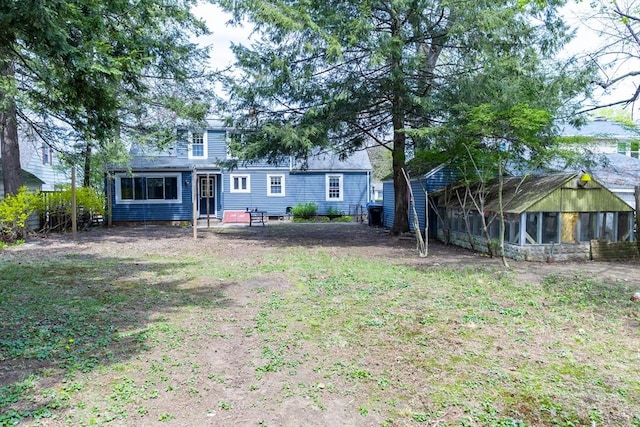 rear view of house featuring a sunroom and a chimney
