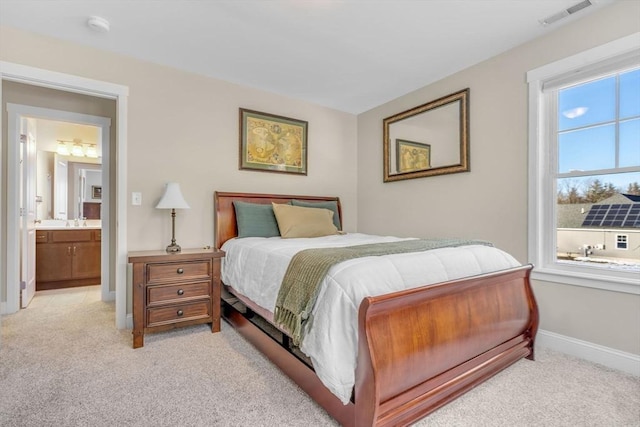 bedroom with light carpet, a sink, visible vents, and baseboards