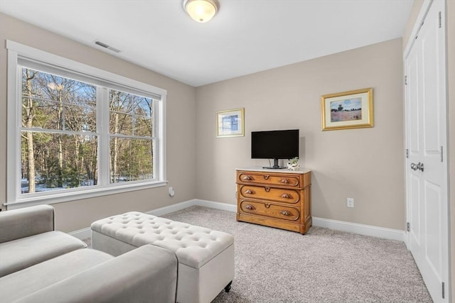 living area with light carpet, visible vents, and baseboards