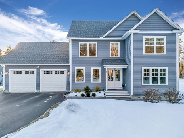 view of front facade featuring french doors, an attached garage, a shingled roof, and aphalt driveway