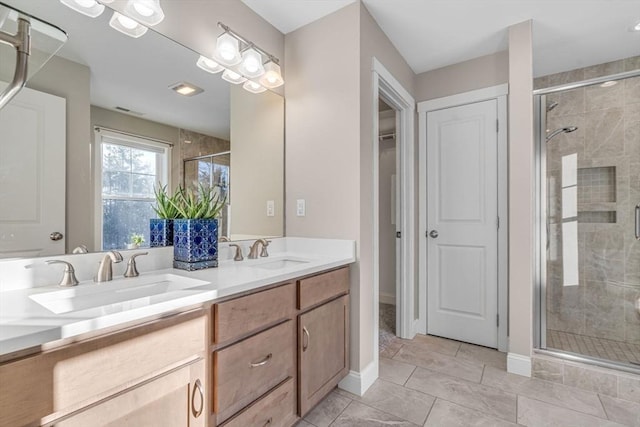 full bath with a stall shower, a sink, baseboards, and double vanity