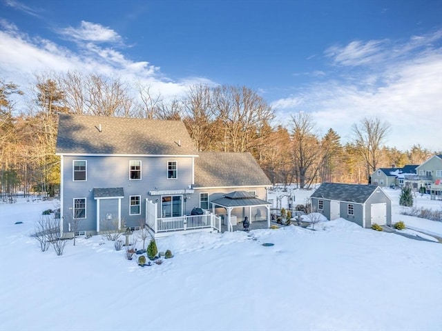 snow covered house featuring a gazebo and a detached garage