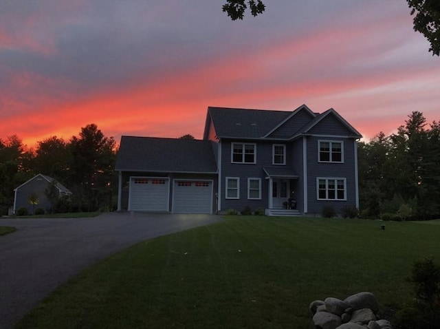 view of front of house featuring an attached garage, concrete driveway, and a front yard