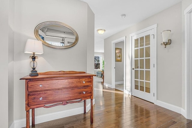 hall featuring baseboards and hardwood / wood-style floors