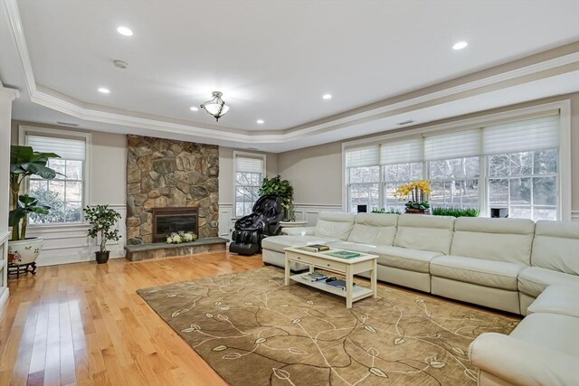 42 Westerly Rd, Weston, MA 02493 - living room featuring a raised ceiling, wood finished floors, a wainscoted wall, a fireplace, and a decorative wall