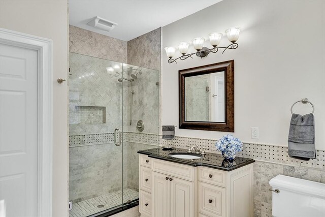 42 Westerly Rd, Weston, MA 02493 - full bathroom featuring tile walls, a stall shower, toilet, vanity, and a wainscoted wall