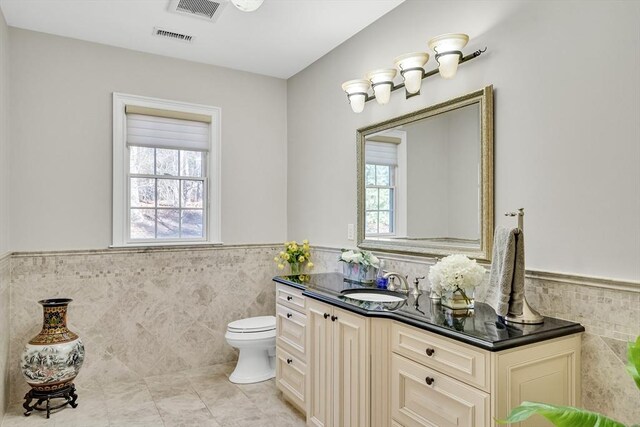 42 Westerly Rd, Weston, MA 02493 - bathroom with tile walls, wainscoting, vanity, tile patterned floors, and toilet