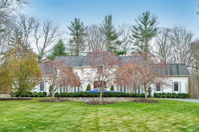 42 Westerly Rd, Weston, MA 02493 - view of front of house with a front yard, stucco siding, and mansard roof