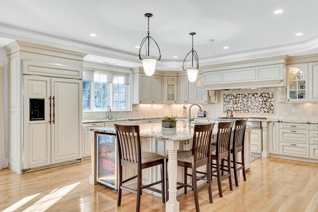 42 Westerly Rd, Weston, MA 02493 - kitchen with beverage cooler, paneled built in fridge, an island with sink, light stone counters, and glass insert cabinets