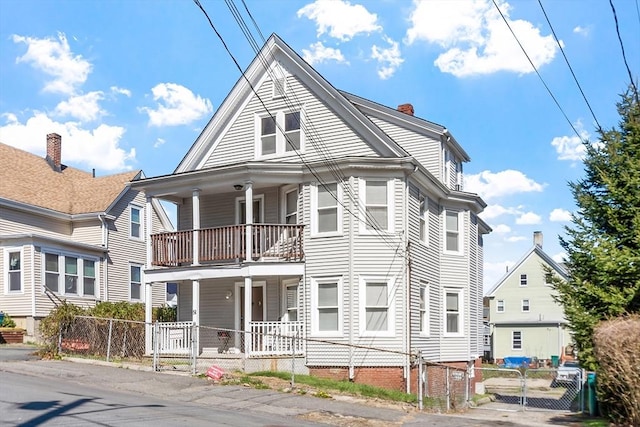 view of front of property with a gate, a porch, a balcony, and fence private yard