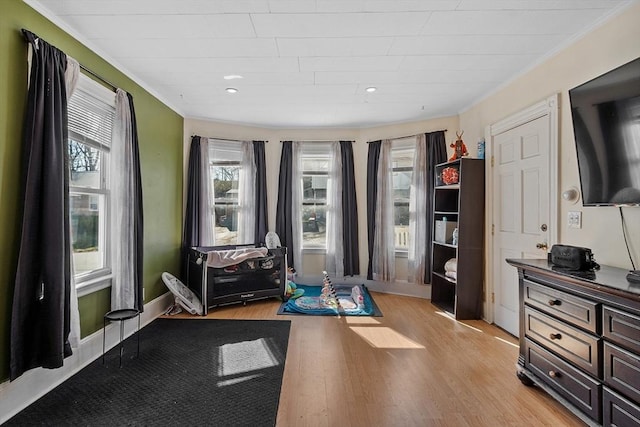 interior space with baseboards, ornamental molding, light wood-style floors, and recessed lighting
