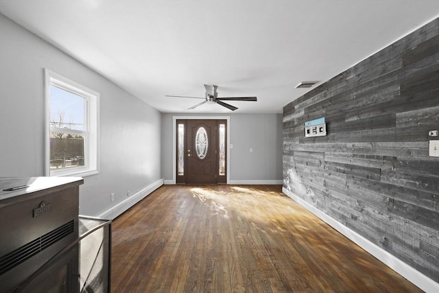 entryway with hardwood / wood-style flooring, ceiling fan, and wooden walls