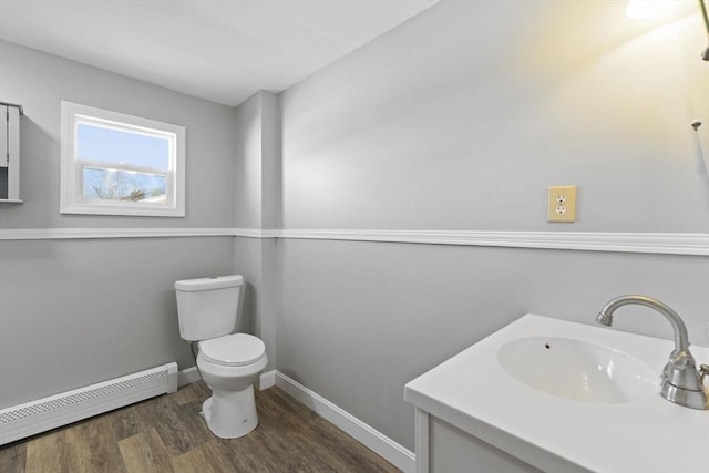 bathroom featuring a baseboard radiator, hardwood / wood-style flooring, toilet, and vanity