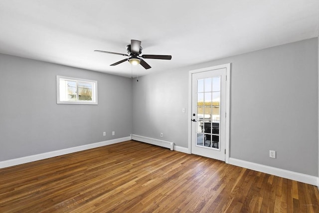 spare room with ceiling fan, hardwood / wood-style floors, baseboard heating, and plenty of natural light