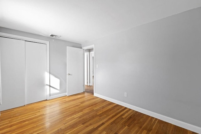 unfurnished bedroom featuring light hardwood / wood-style flooring and a closet