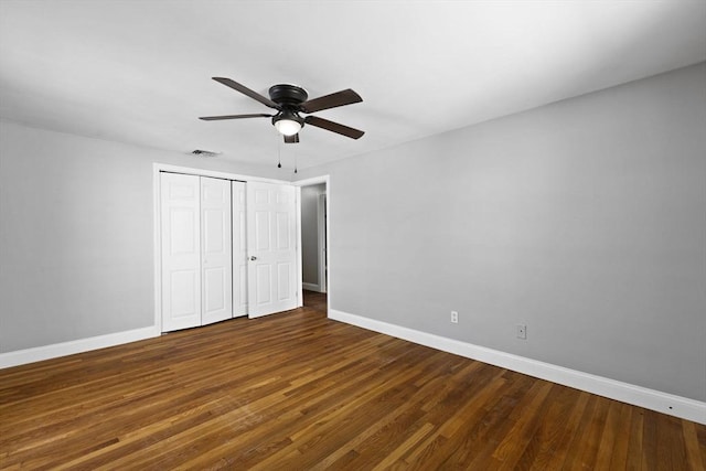 unfurnished bedroom with ceiling fan, dark hardwood / wood-style floors, and a closet