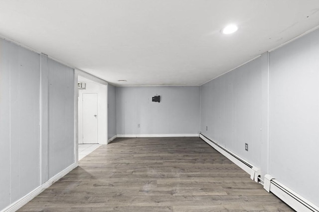 empty room with a baseboard radiator and hardwood / wood-style floors