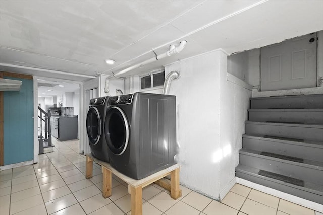 laundry area with light tile patterned floors and washer and clothes dryer