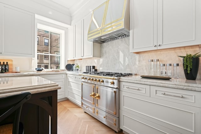 kitchen with light stone counters, custom exhaust hood, and white cabinetry