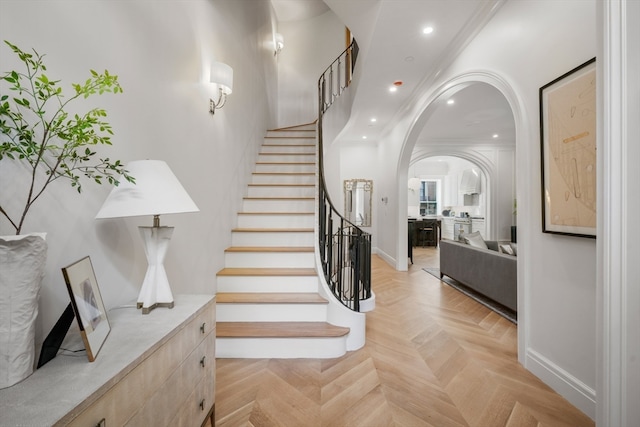 stairs featuring parquet flooring and crown molding