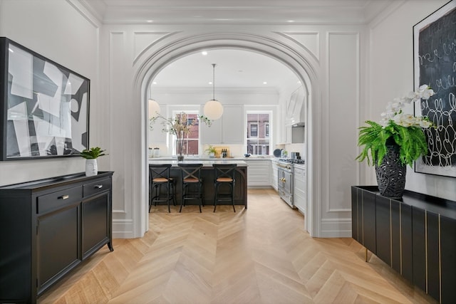 interior space with ornamental molding and light parquet flooring